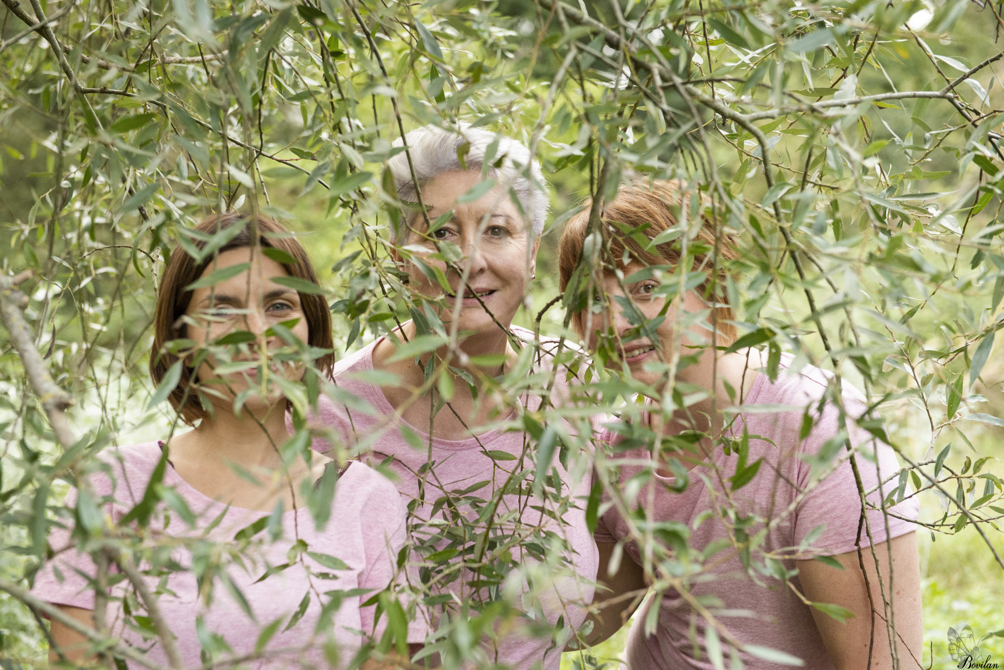 Au milieu d'une végétation verdoyante, 3 femmes, ou plutôt 3 têtes souris au dessus d'un tronc d'arbre couvert de lierre 